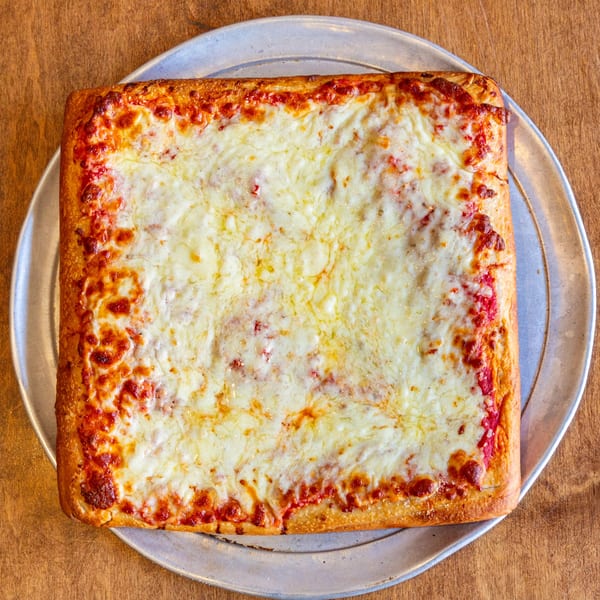 Square San Vito's pizza with melted cheese and red sauce on a metal tray.