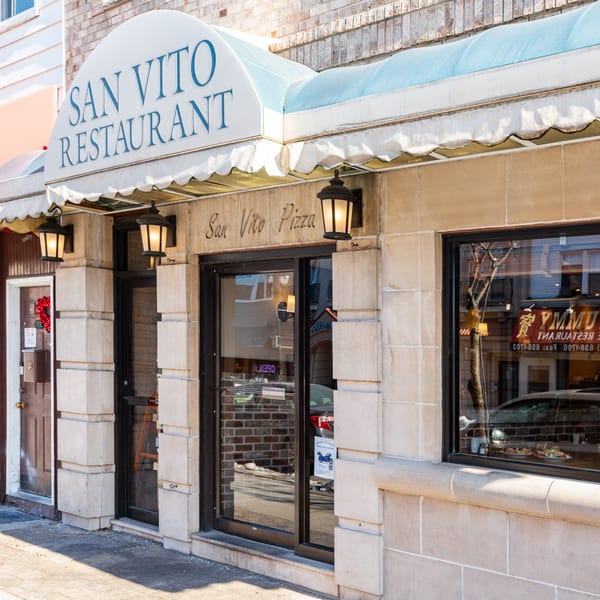 Exterior of San Vito's Restaurant & Pizzeria, featuring a white awning and stone facade.